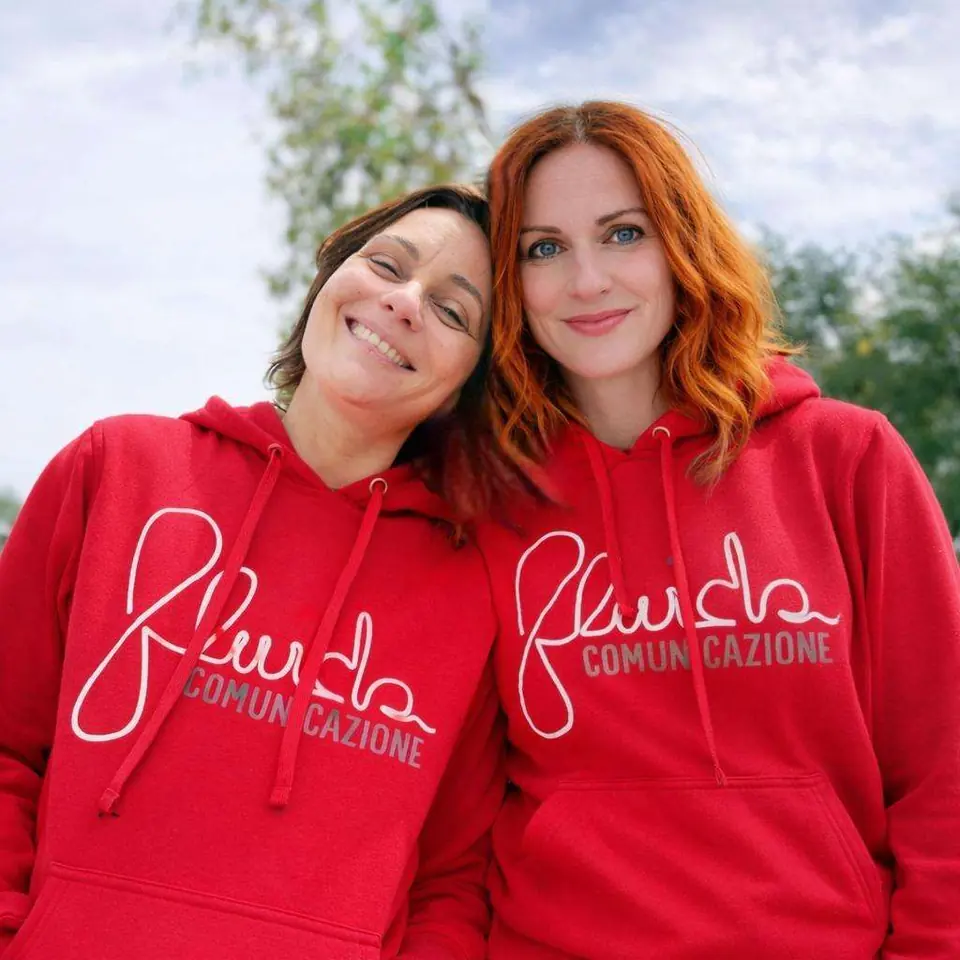 Le fondatrici di Fluida Comunicazione con le felpe rosse col logo